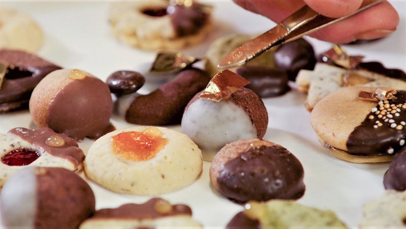 Nahaufnahme Plätzchen, die mit Blattgold dekoriert werden. | Bild: BR Nahaufnahme Plätzchen, die mit Blattgold dekoriert werden.