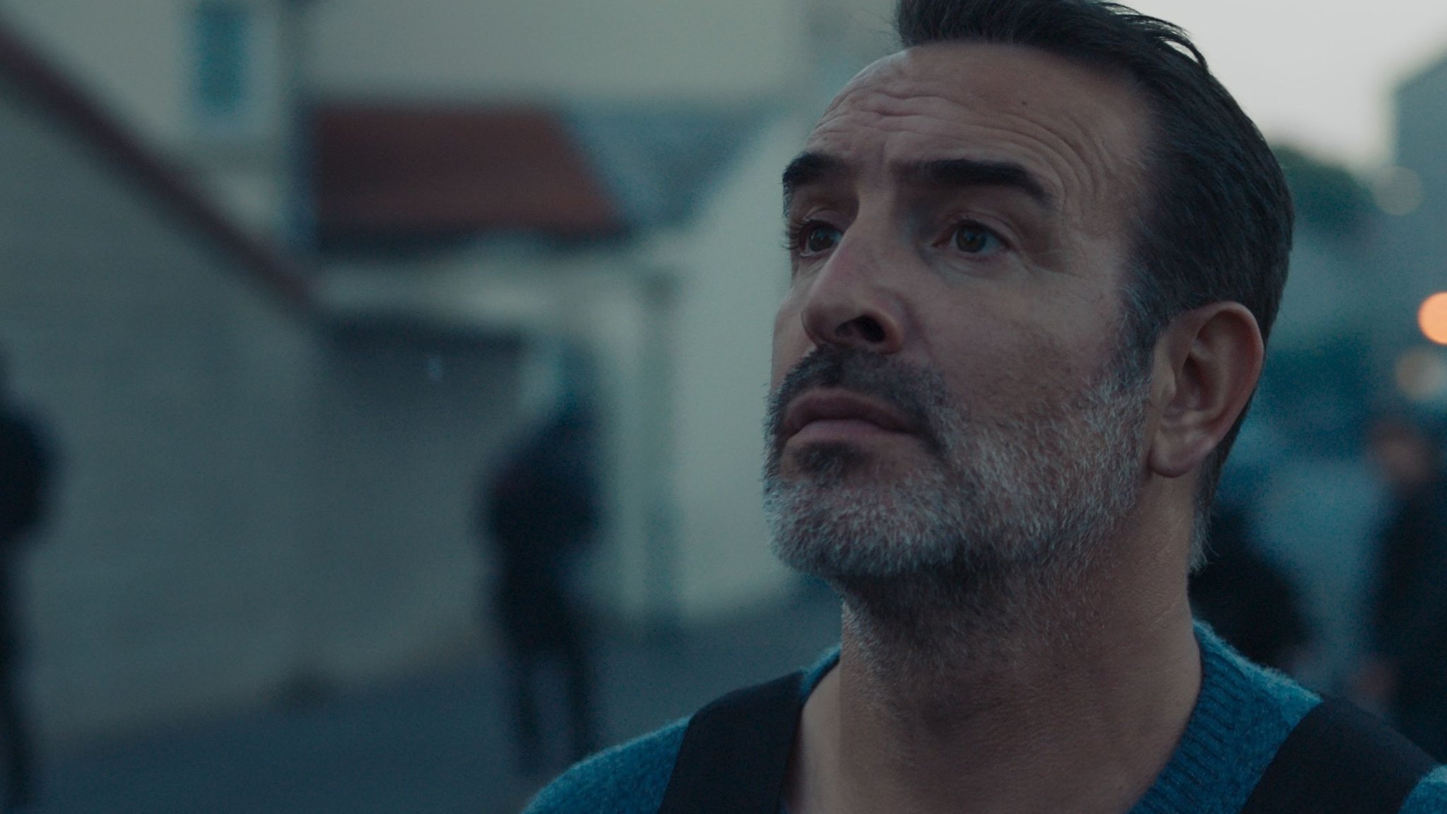 Fred (Jean Dujardin) schaut mit ernster Mine nach oben, Filmszene aus "November".