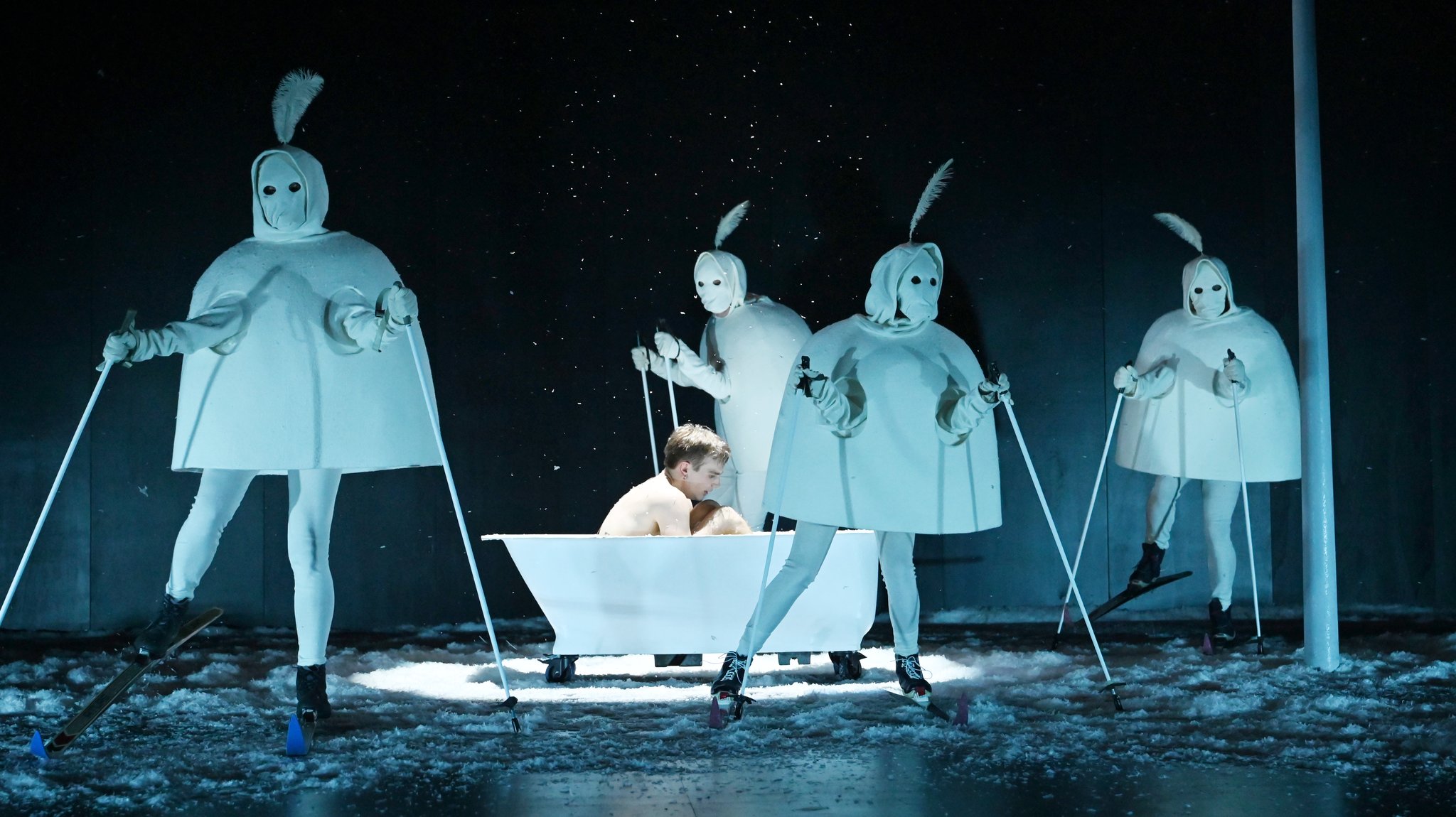 Zu sehen: Figur Behrendt in einer Badewanne, um ihn herum seltsame Gestalten in weißem Kostüm mit Skier auf Kunstschnee. | Bild: Martin Kaufhold Zu sehen: Figur Behrendt in einer Badewanne, um ihn herum seltsame Gestalten in weißem Kostüm mit Skier auf Kunstschnee.