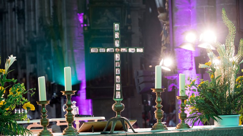 Symbolbild: Auf dem Altar in der Sebalduskirche steht ein Kreuz neben Kerzen und Blumen beim 38. Deutschen Evangelischen Kirchentag in Nürnberg. | Bild: picture alliance/dpa | Daniel Vogl Symbolbild: Auf dem Altar in der Sebalduskirche steht ein Kreuz neben Kerzen und Blumen beim 38. Deutschen Evangelischen Kirchentag in Nürnberg.