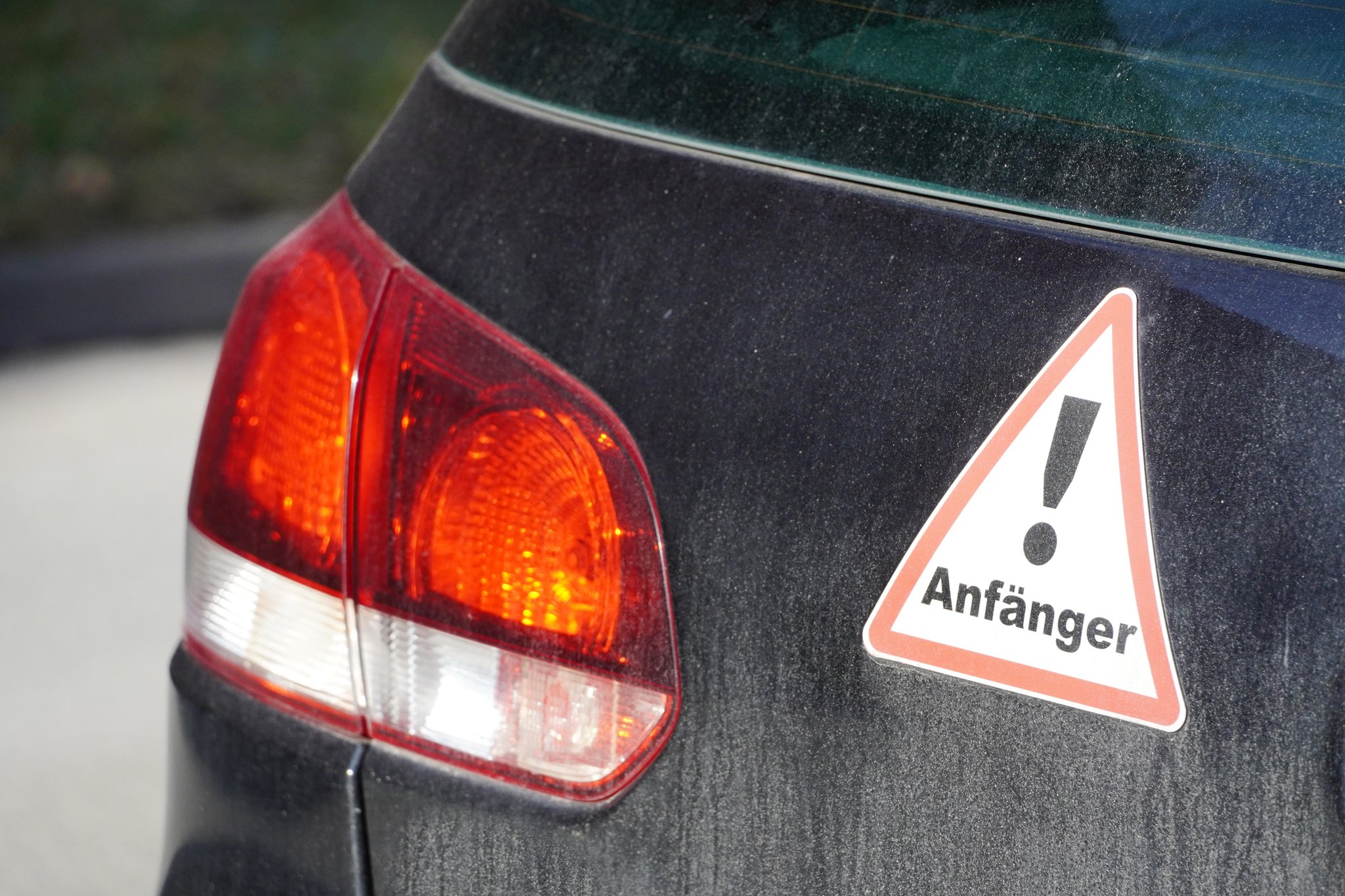 Heck eines verschmutzten PKW mit einem Aufkleber, Achtung Fahranfänger, besondere Vorsicht und Rücksichtnahme im Straßenverkehr