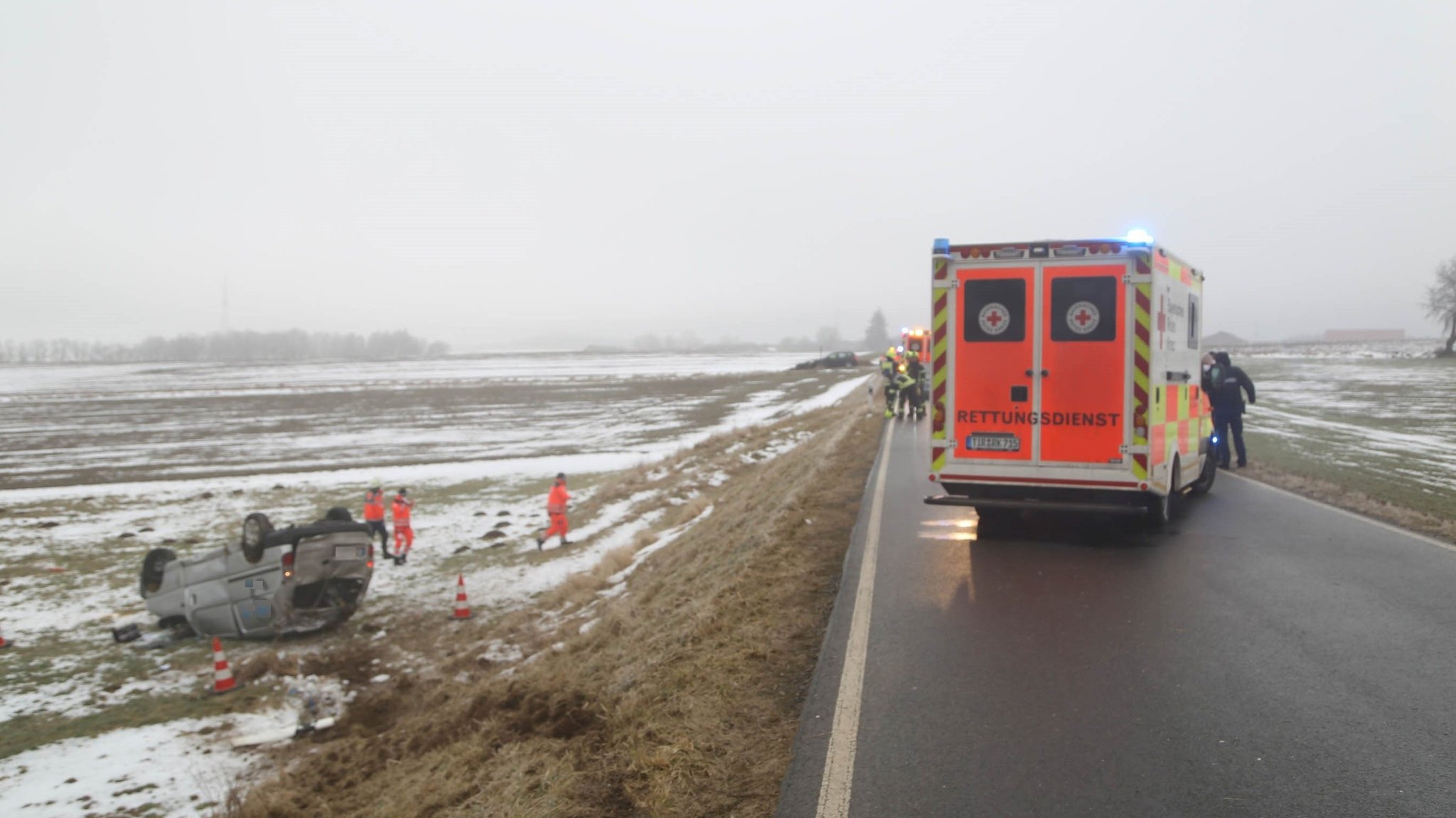 Das verunglückte Auto liegt auf dem Dach im Straßengraben