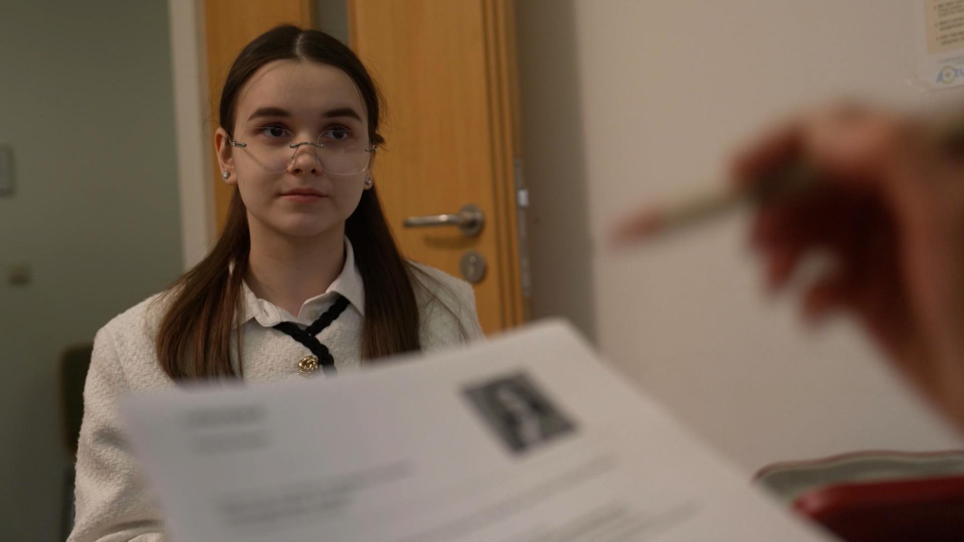 Eine junge Frau sitzt beim Bewerbungsgespräch.