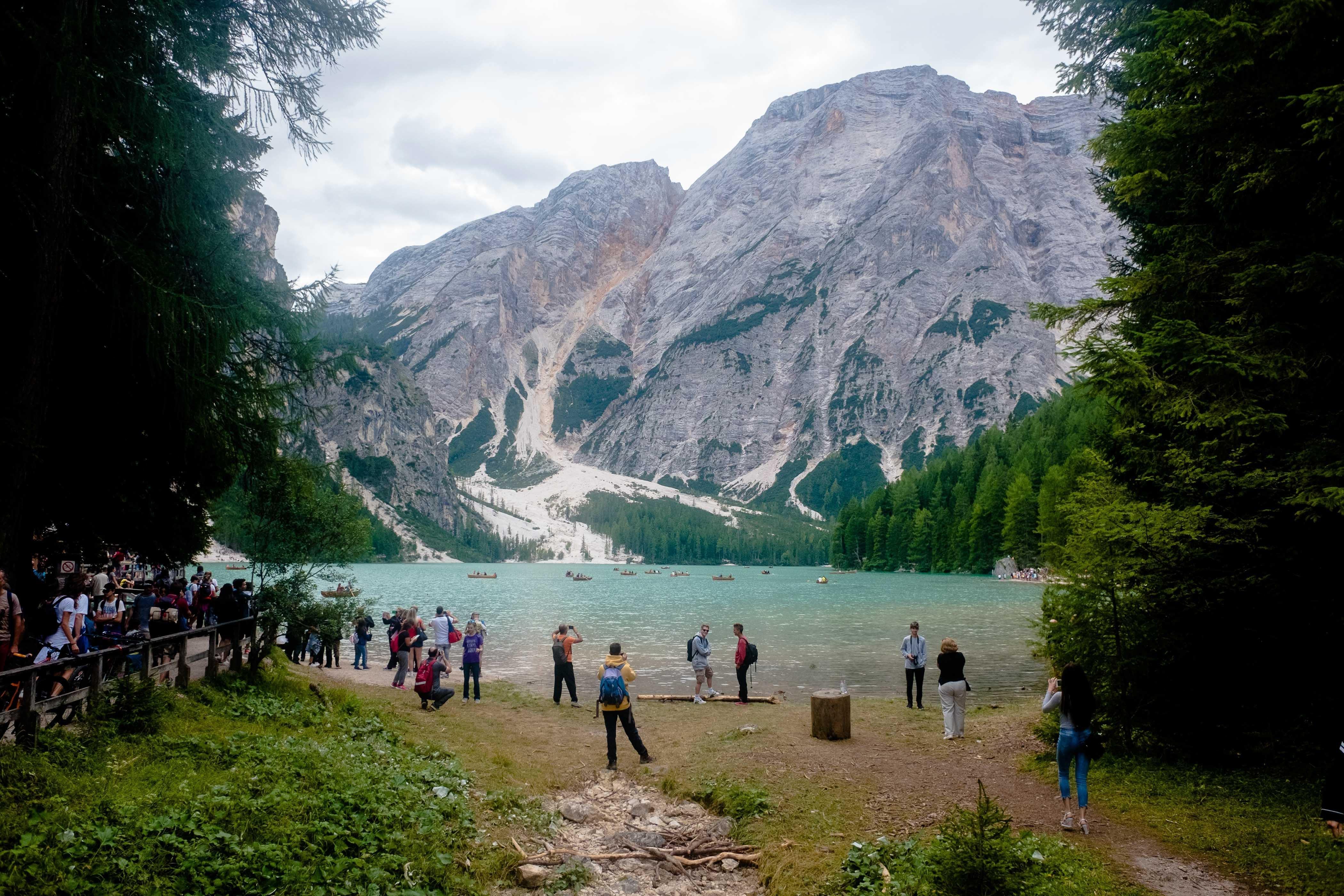 Besucherinnen und Besucher machen Fotos am Pragser Wildsee.