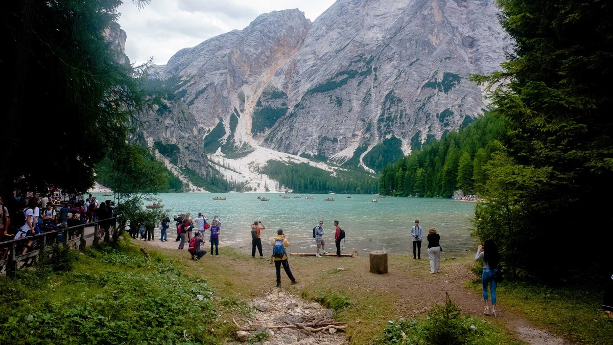 Besucherinnen und Besucher machen Fotos am Pragser Wildsee. | Bild: picture alliance / Pacific Press | Mairo Cinquetti Besucherinnen und Besucher machen Fotos am Pragser Wildsee.