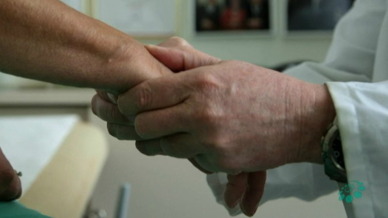 Arzt hält die Hände eines Rheuma-Patienten