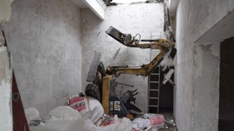 Der durch die Decke gestürze Minibagger | Bild: BR/Polizeipräsidium München Der durch die Decke gestürze Minibagger