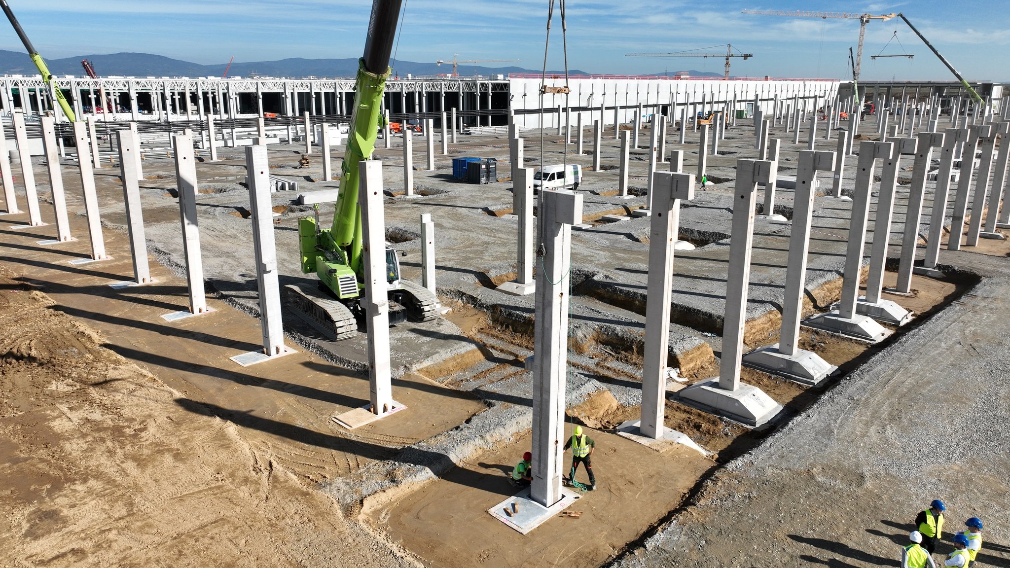 Ein Kran hievt auf der BMW-Baustelle in Straßkirchen die letzte Betonstütze an ihren Platz.