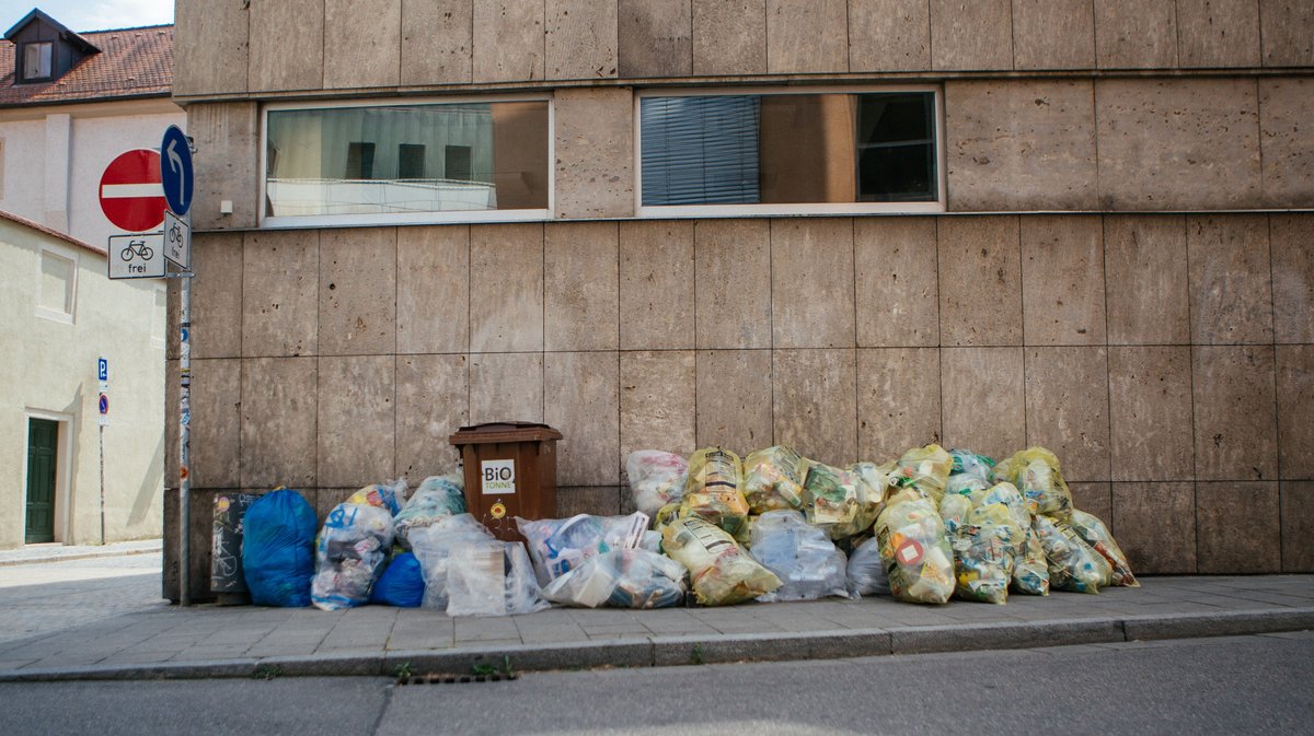 Volle Mülltüten liegen an der Straße