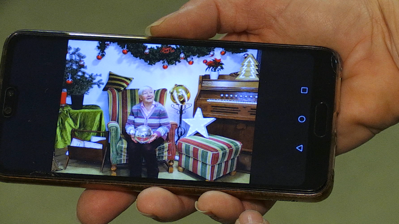 Eine Hand hält ein Handy, auf dem das fertige Foto des Shootings zu sehen ist.