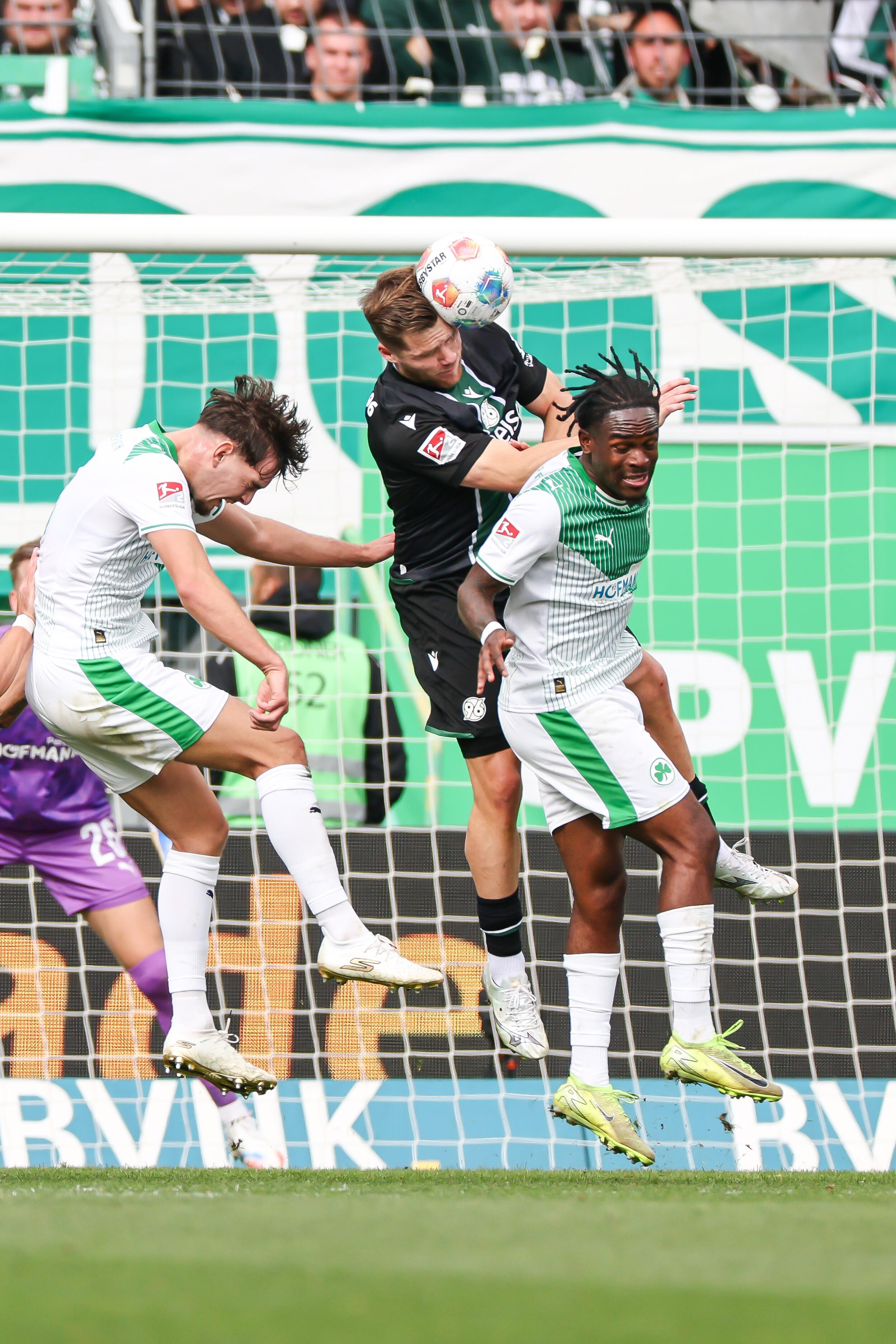 Benjamin Källmann von Hannover 96 (M), Reno Morris Münz (l) und Noel Futkeu von Greuther Fürth (l) in Aktion.