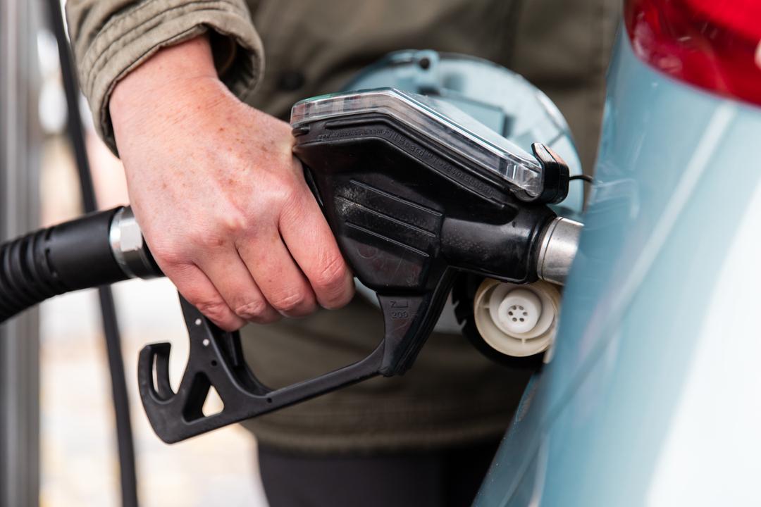 Eine Frau tankt ihr Auto an einer Tankstelle auf.