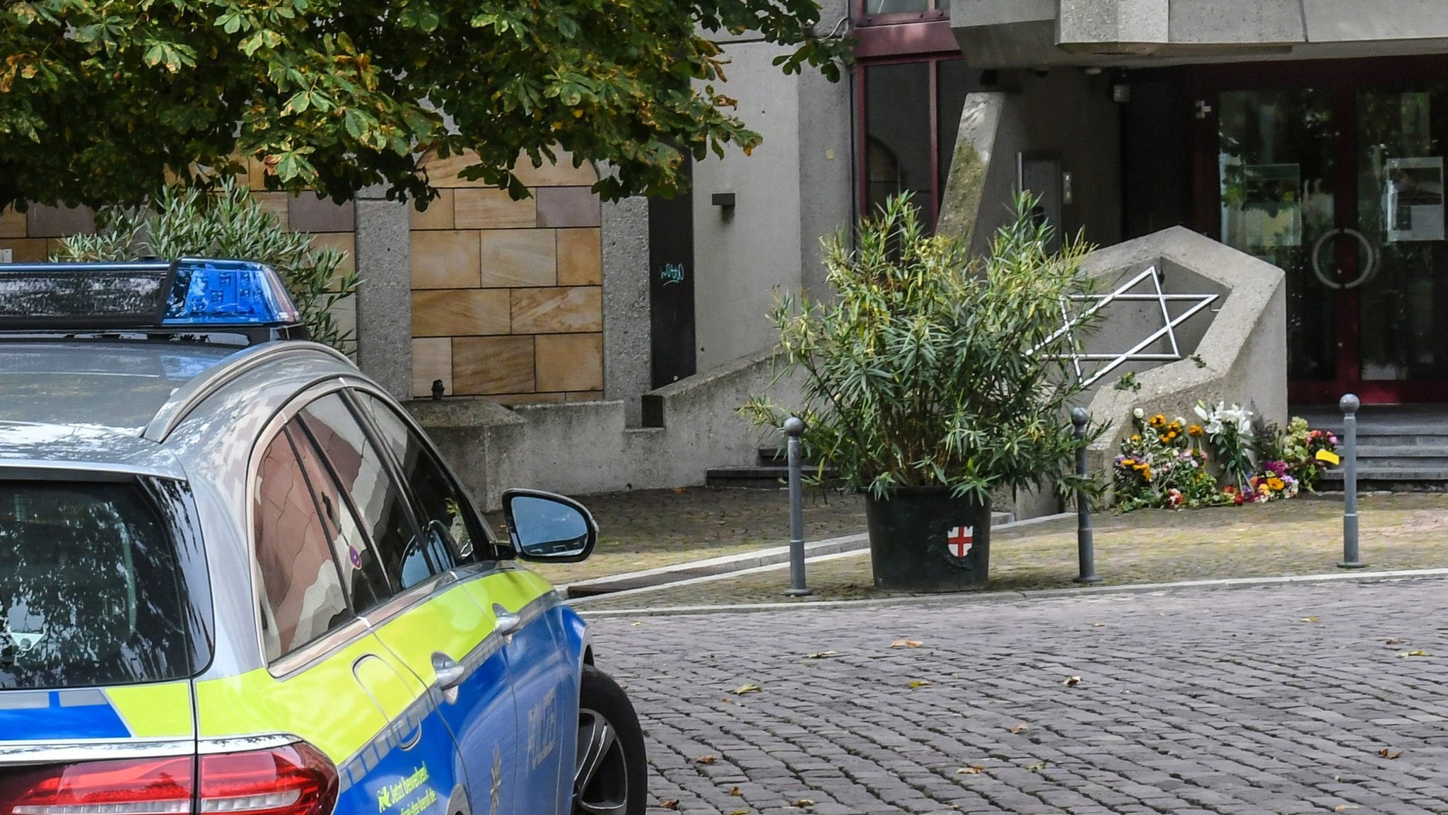 Nach dem Anschlag in Halle 2019. Polizeiauto und Blumen: Trauer und Gedenken auch an der Synagoge in Freiburg. 