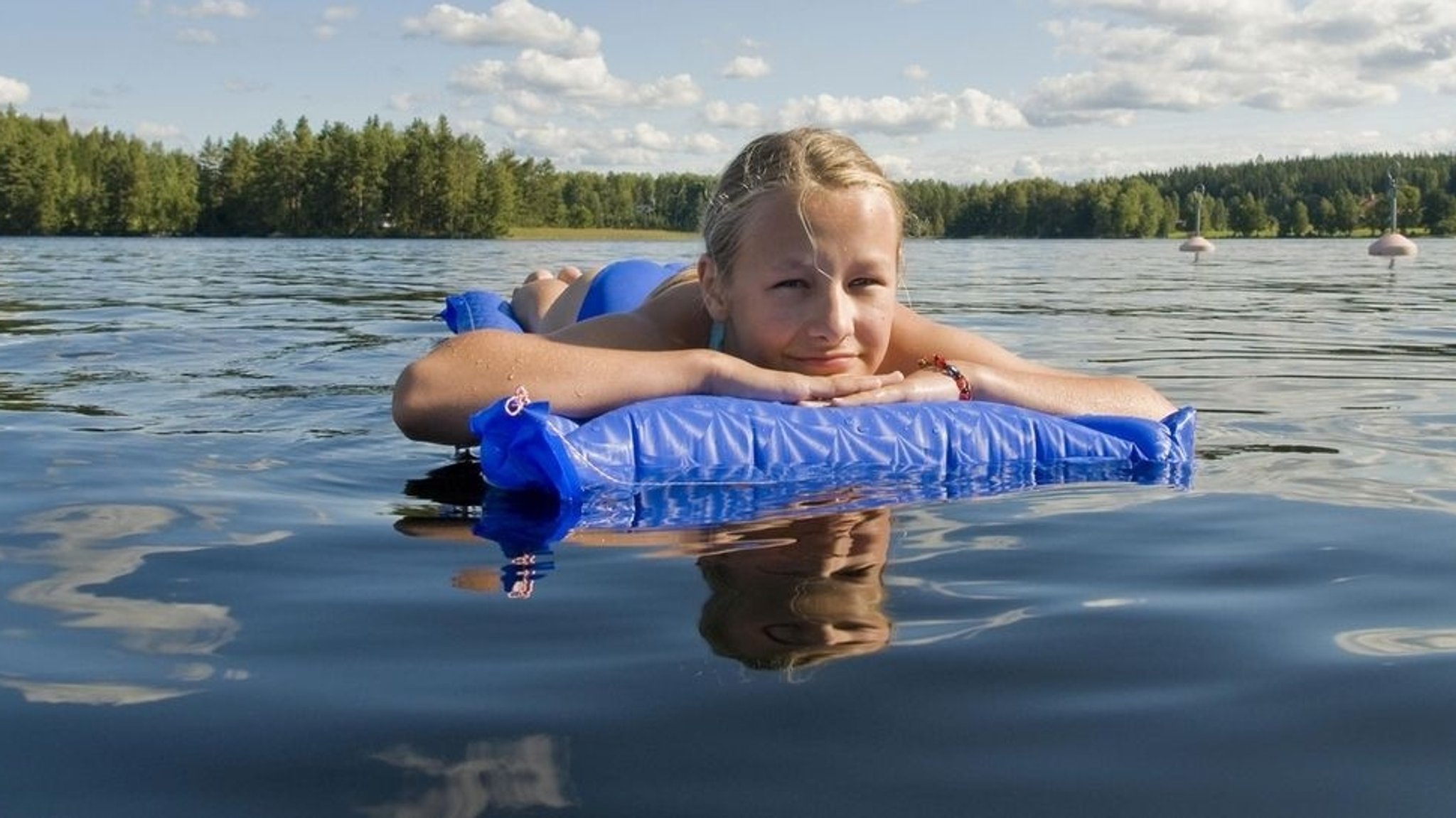 Mädchen treibt mit Luftmatratze auf einem See. | Bild: picture-alliance/dpa Mädchen treibt mit Luftmatratze auf einem See.