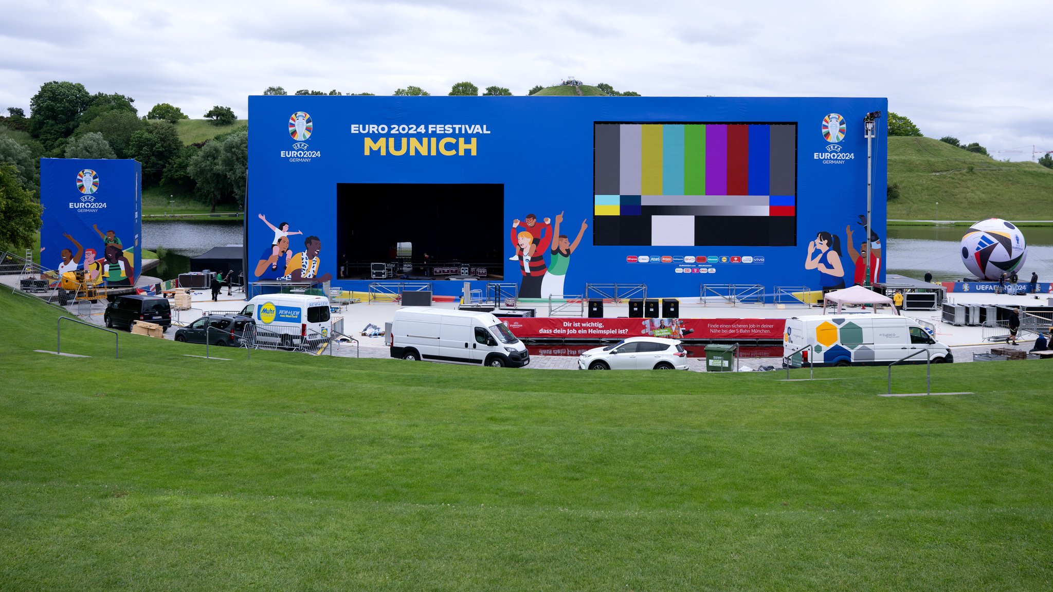 Arbeiter bauen im Olympiapark eine Bühne und eine Leinwand für die Fan-Zone auf. 