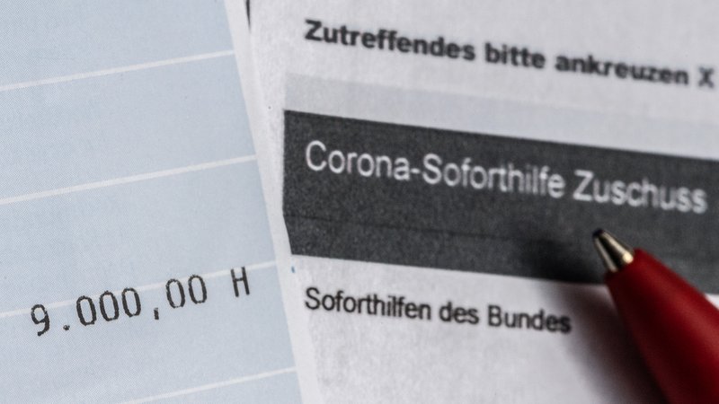 Ein Kontoauszug mit der überwiesenen Summe von 9.000 Euro Corona-Soforthilfe liegt auf einem Antrag für den Zuschuss der Sächsischen Aufbaubank.