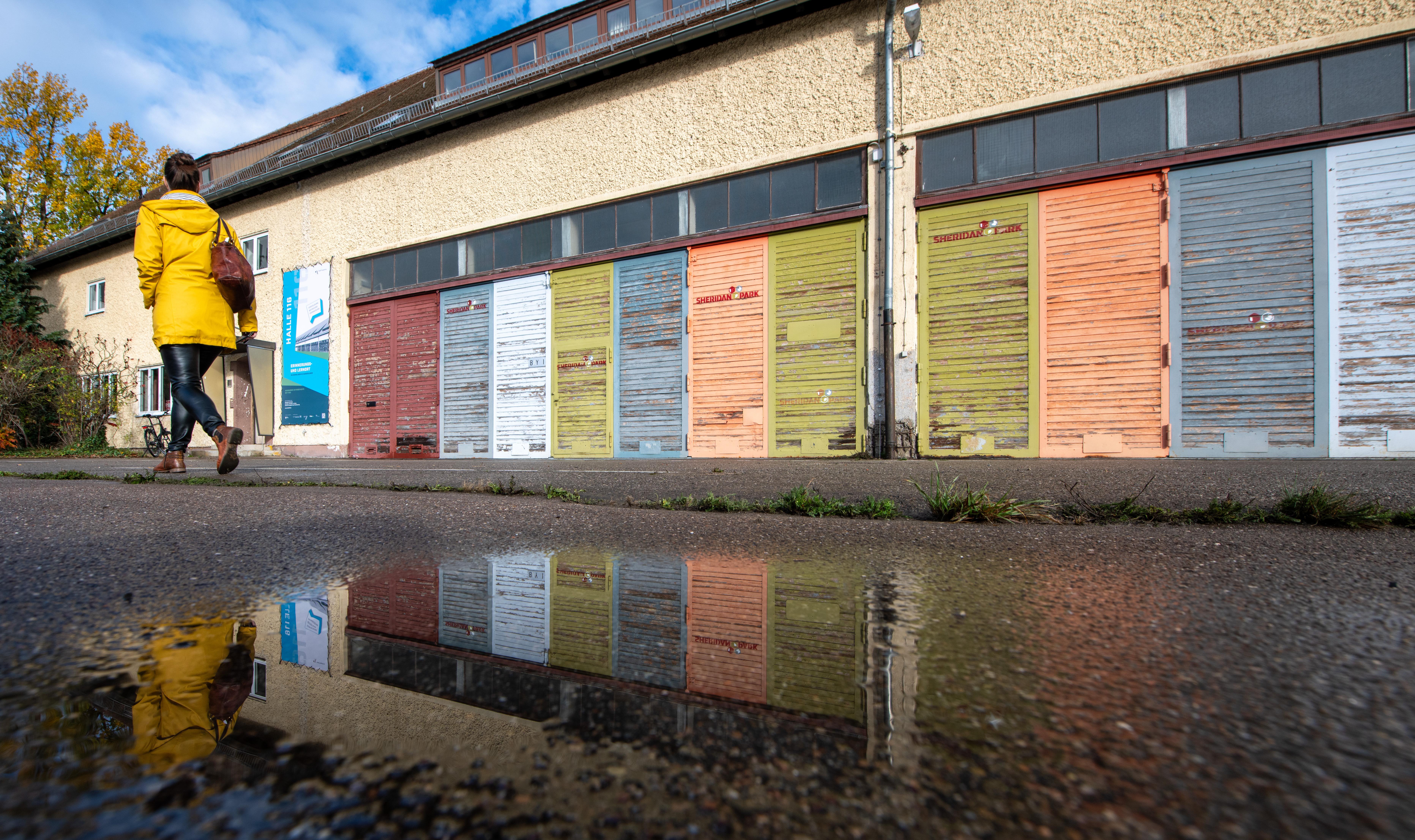 Die Halle 116 in Augsburg: Ein langer zweistöckiger Bau mit vielen bunten geschlossenen Jalousien.