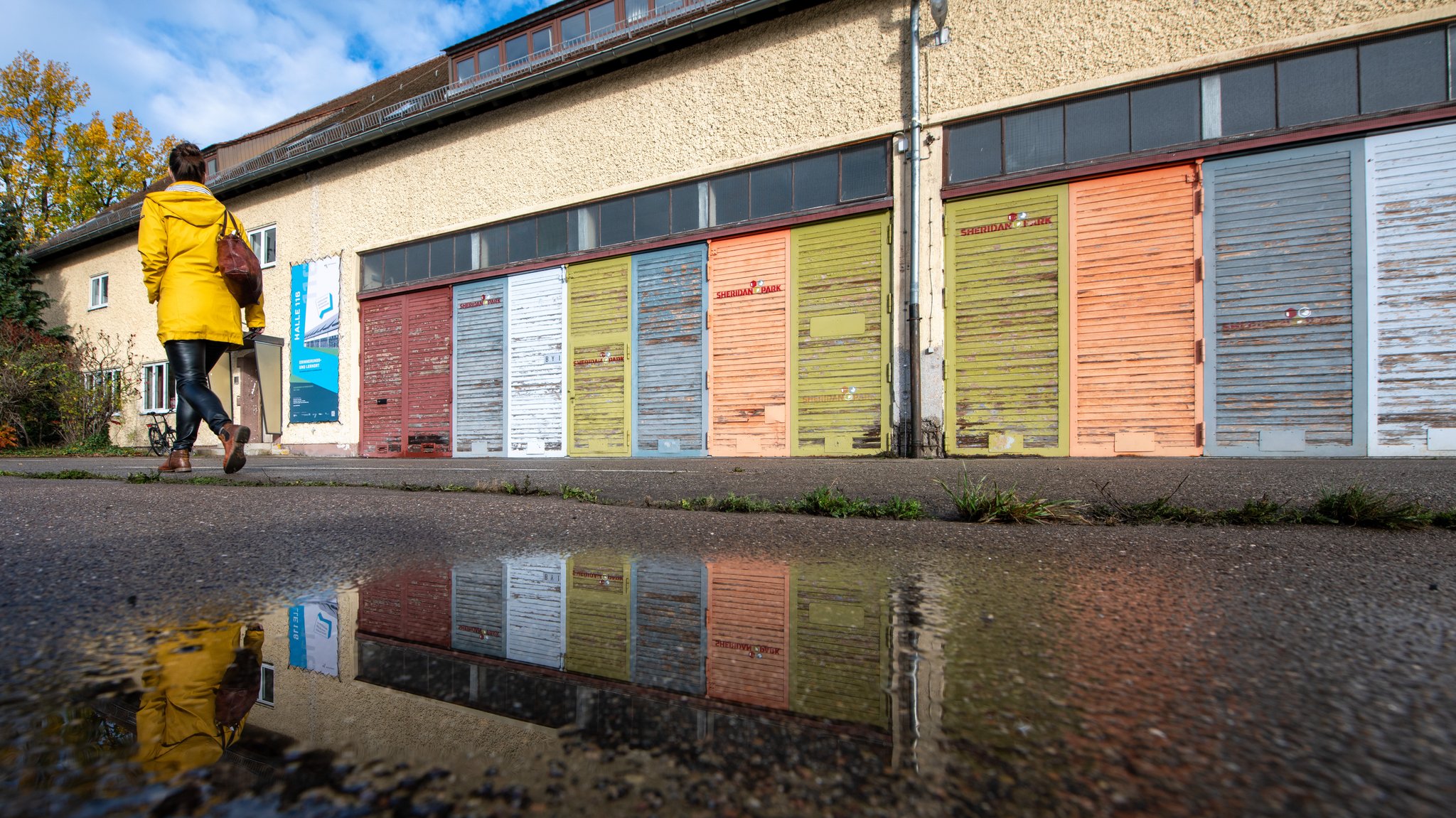 Die Halle 116 in Augsburg: Ein langer zweistöckiger Bau mit vielen bunten geschlossenen Jalousien.