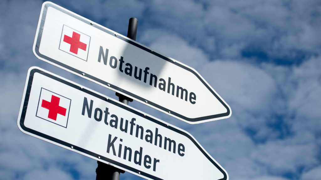 Zwei Schilder mit der Aufschrift "Notaufnahme" und "Notaufnahme Kinder" stehen vor einem Krankenhaus.