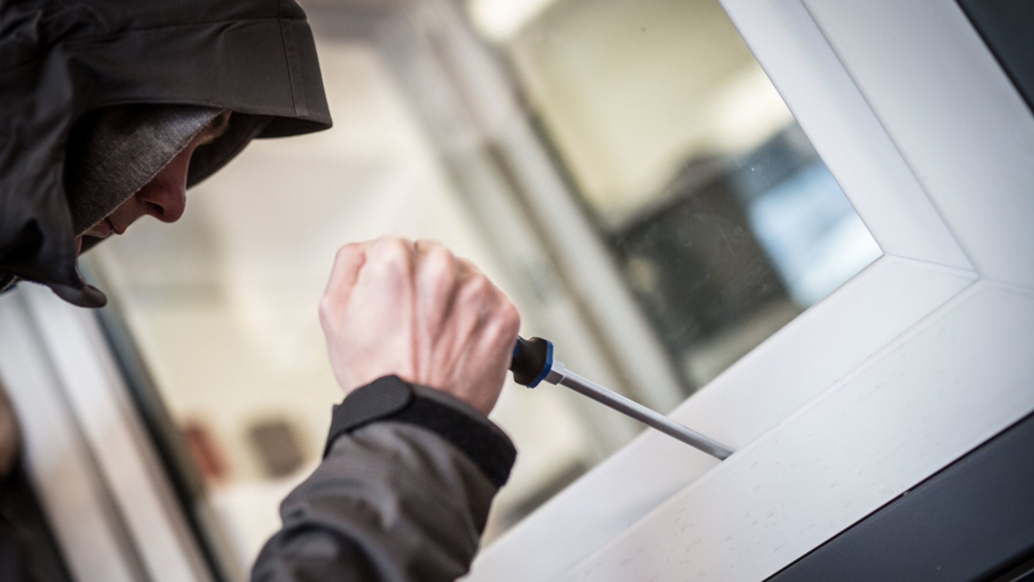 Vermummter Mann versucht Fenster aufzuhebeln.