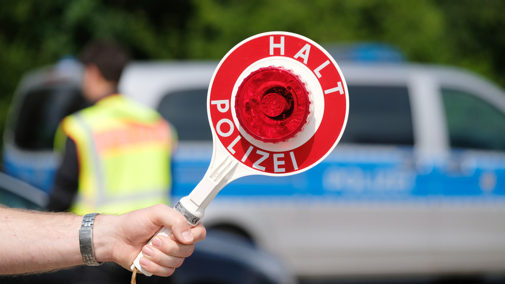 Polizei mit roter Warnkelle (Symbolbild)