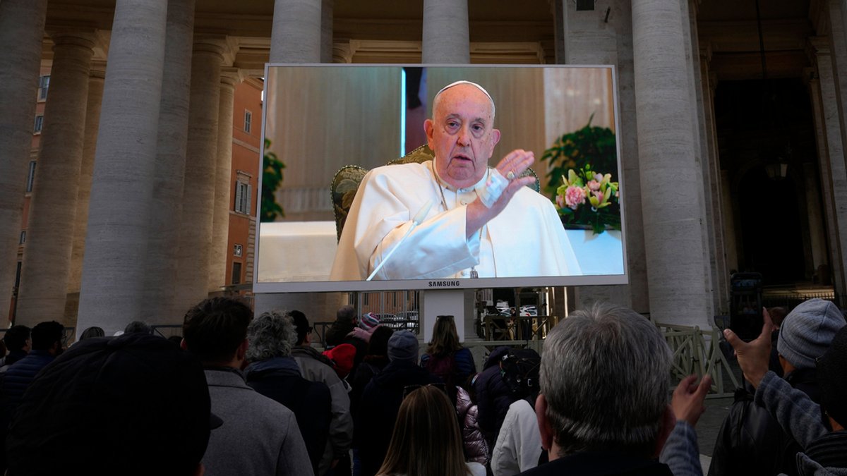 Papst Franziskus ist auf einem Monitor auf dem Petersplatz zu sehen, um die Gläubigen zu segnen.