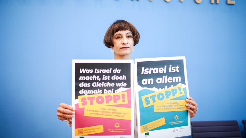 Tahera Ameer, Vorsitzende der Amadeu Antonio Stiftung, zeigt in der Bundespressekonferenz Plakate zum Thema «Antisemitismus stoppen.
