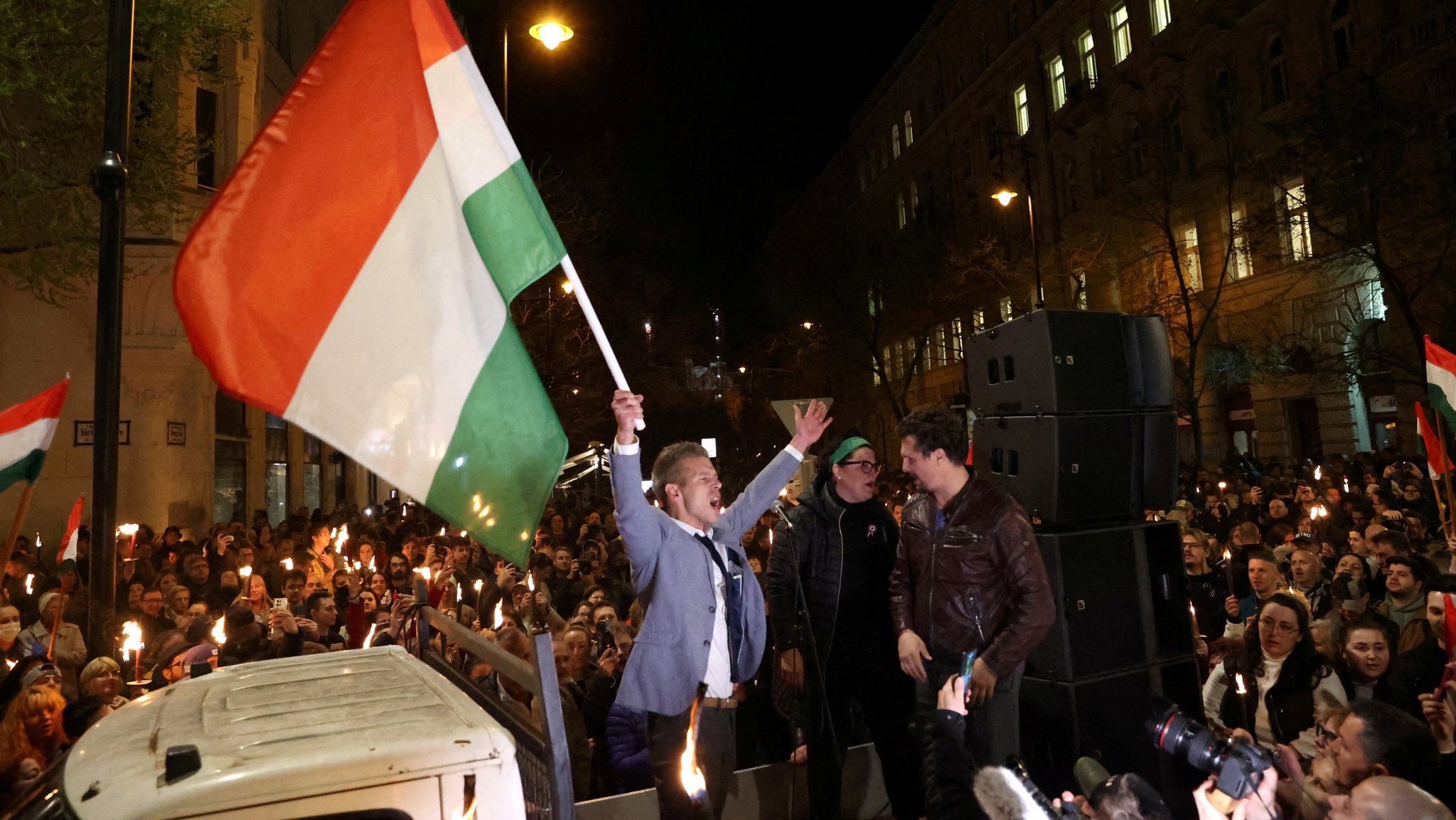 Peter Magyar schwenkt während eines Protests in Ungarn eine Flagge