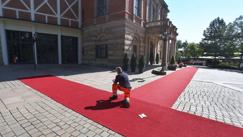 Bayreuth: Der Rote Teppich wird für die Eröffnung der Bayreuther Richard-Wagner-Festspiele, vor dem Festspielhaus auf dem Grünen Hügel befestigt.
