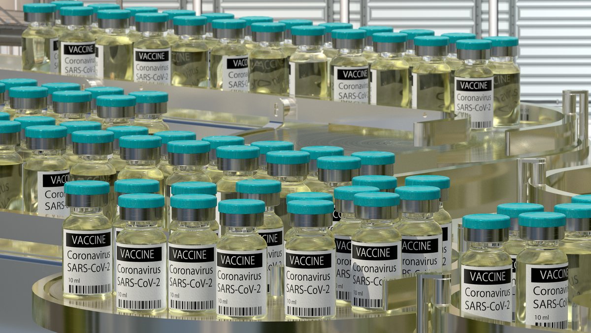 Kleine Flaschen mit Corona-Impfstoff laufen auf dem Förderband