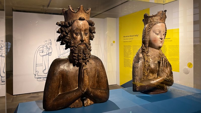 Zwei Plastiken zeigen Kaiser Heinrich II. und seine Frau Kunigunde, die jeweils die Hände zum Gebet falten. | Bild: BR/Sandra Jozipovic Zwei Plastiken zeigen Kaiser Heinrich II. und seine Frau Kunigunde, die jeweils die Hände zum Gebet falten.