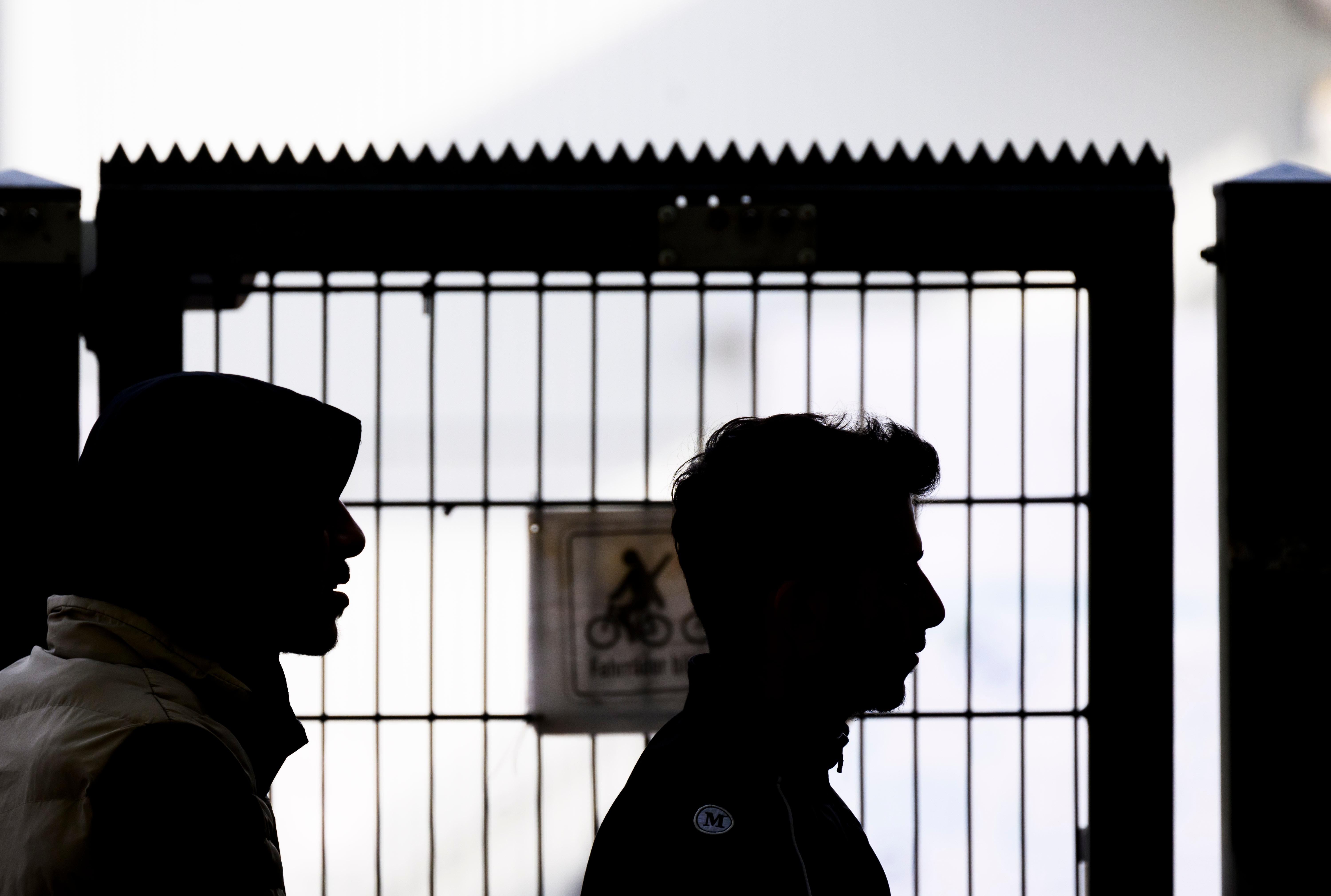 Zwei Männer stehen am Eingangstor der Landesaufnahmebehörde Niedersachsen am Standort Braunschweig.