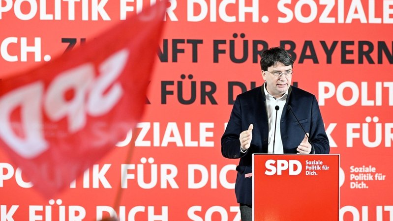 Ein Parteimitglied schwenkt beim Politischen Aschermittwoch im Wolferstetter Keller während der Rede von SPD Landeschef von Bayern Florian von Brunn eine SPD Fahne.