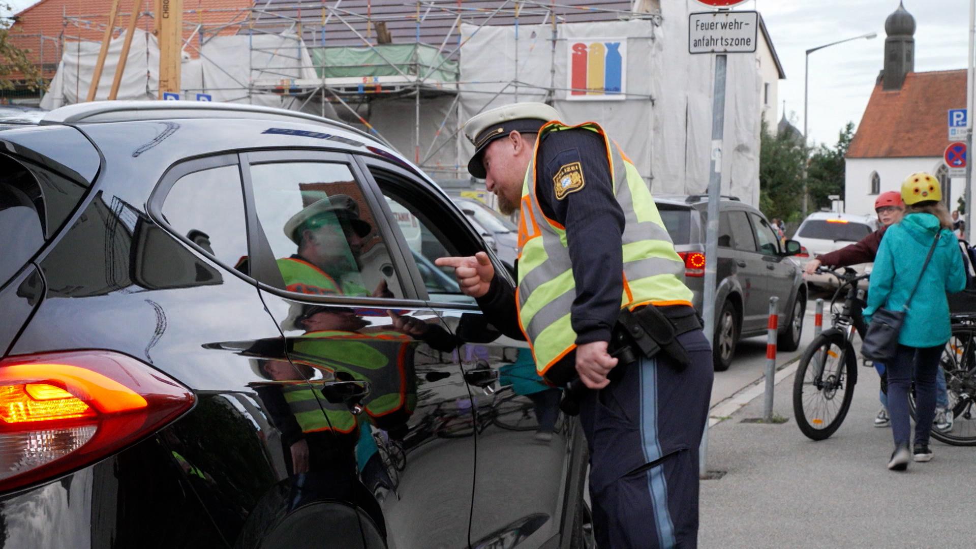 Polizist am Auto spricht mit Fahrer.