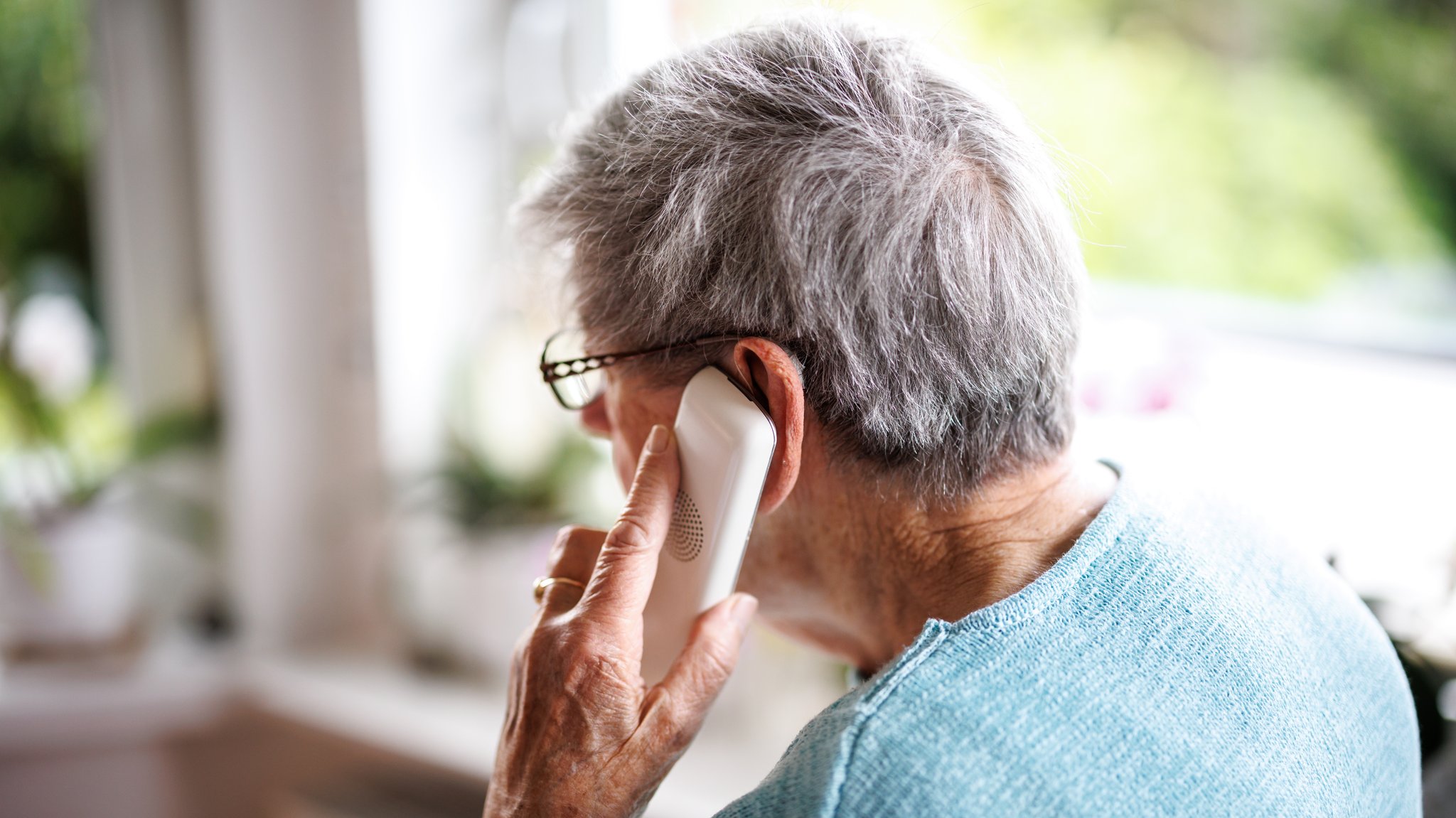 Eine Seniorin führt ein Telefongespräch.