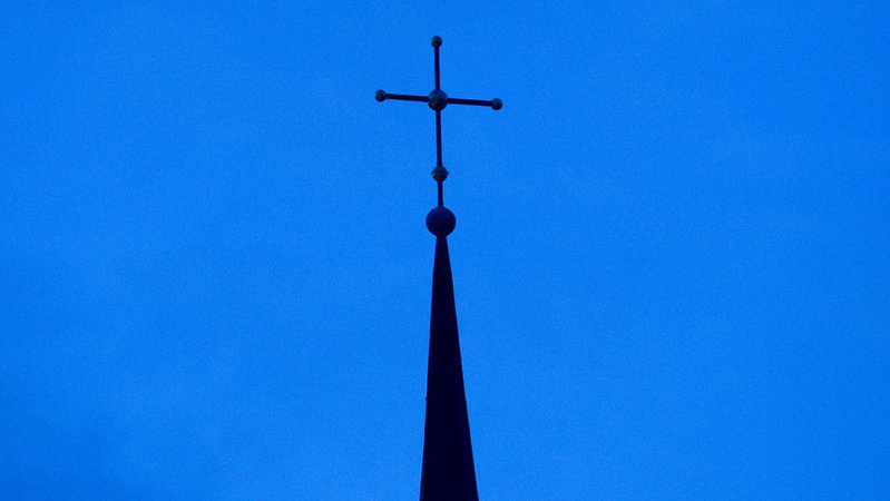 Ein Kirchenkreuz ragt in den blauen Himmel. | Bild: dpa-Bildfunk/Friso Gentsch Ein Kirchenkreuz ragt in den blauen Himmel.