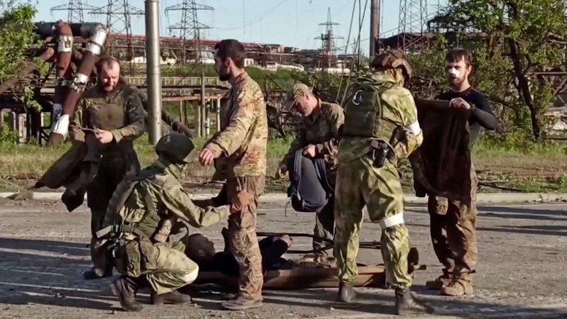Ukrainische Kämpfer, die aus dem belagerten Stahlwerk Azovstal evakuiert wurden, werden von russischen Soldaten durchsucht.