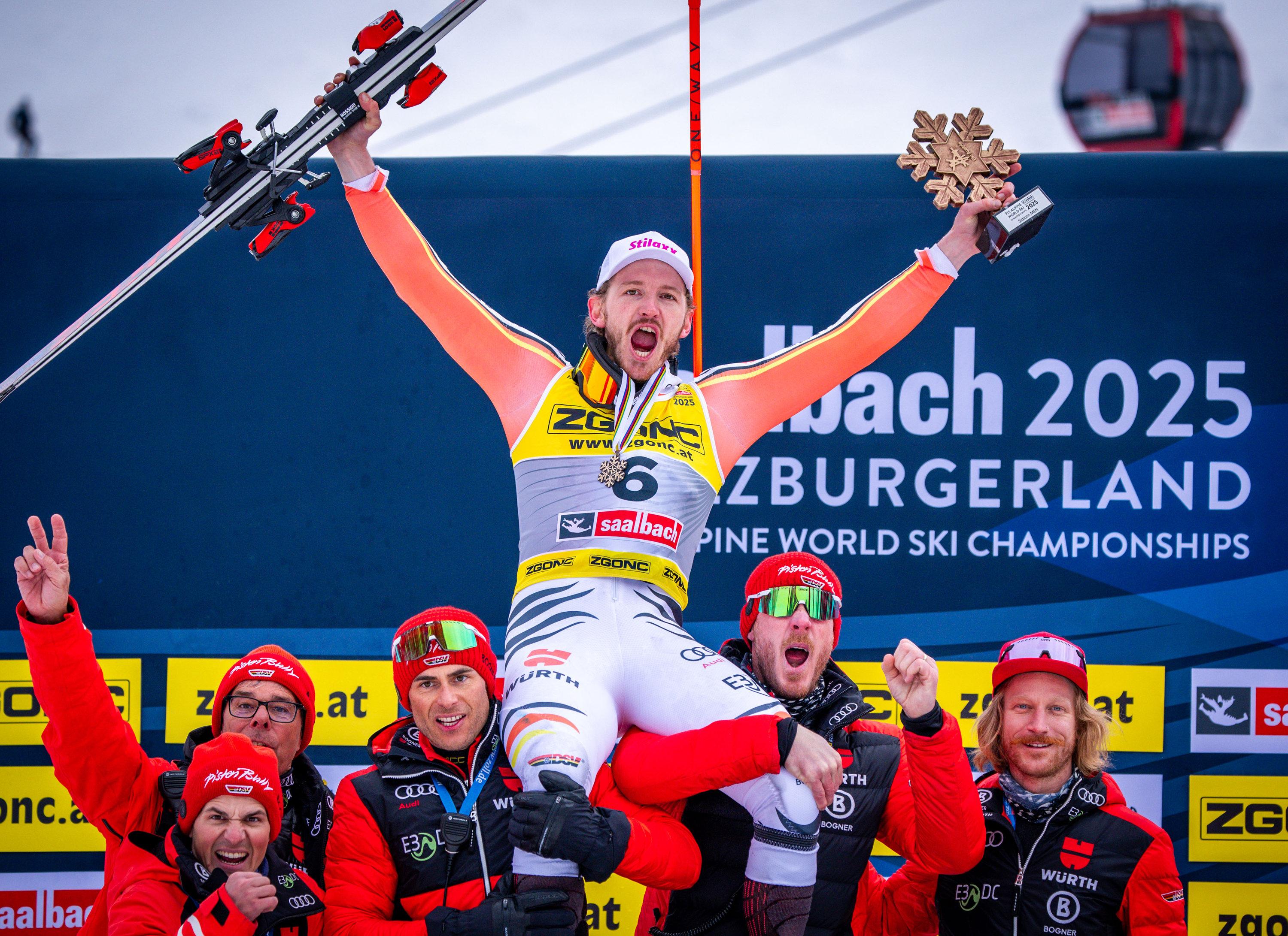 16.02.2025, Österreich, Saalbach-Hinterglemm: Ski alpin: Weltmeisterschaft, Slalom, Herren, 2. Durchgang, Linus Straßer (M) aus Deutschland jubelt nach dem Gewinn der Bronzemedaille mit dem deutschen Skiteam. 