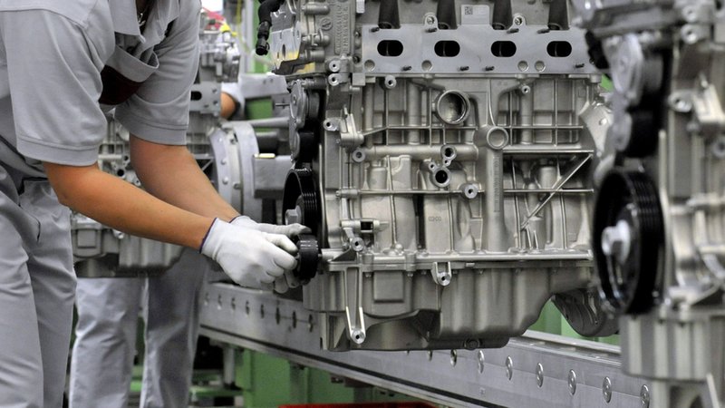 Bei einem Automobilzulieferer montiert eine Mitarbeiterin einen Vierzylinder-Benzinmotor. | Bild: dpa-Bildfunk/Martin Schutt Bei einem Automobilzulieferer montiert eine Mitarbeiterin einen Vierzylinder-Benzinmotor.