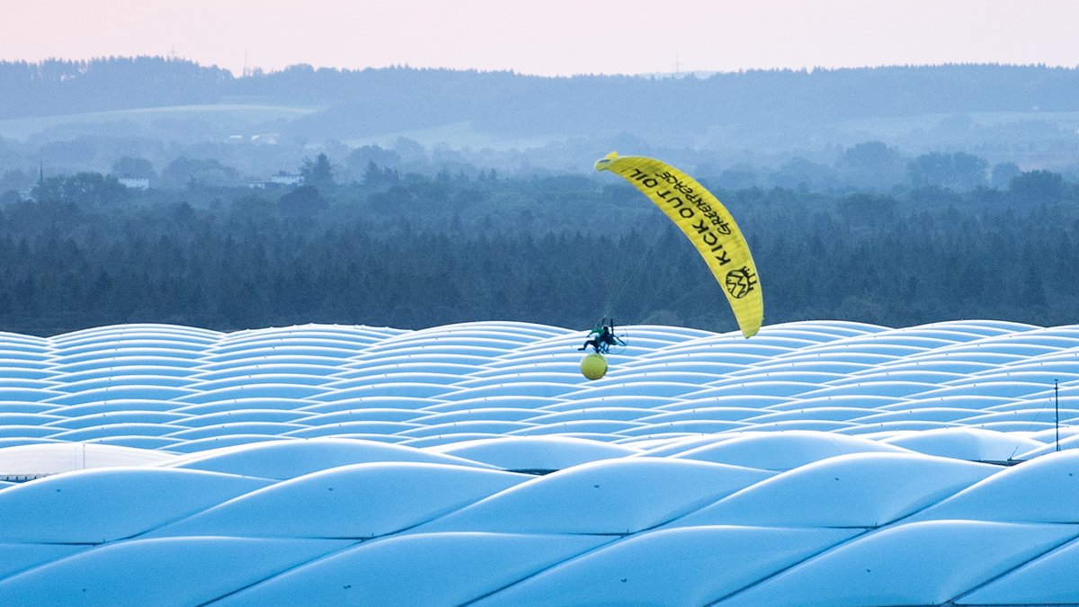 Der Greenpeace-Aktivist segelt über dem Münchner Stadion und verheddert sich