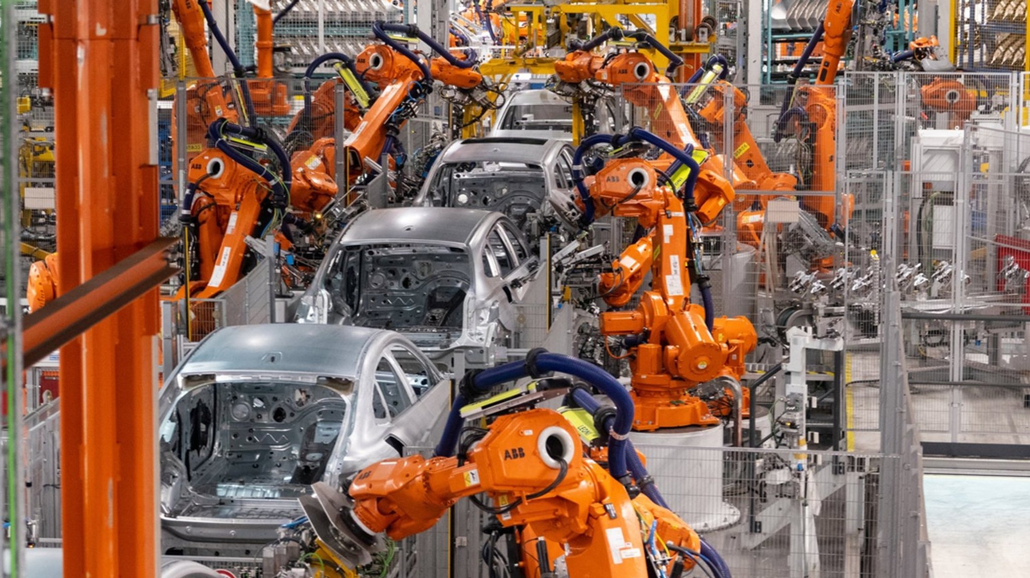 Roboterarme arbeiten an Autokarosserien in einer Produktionshalle | Bild: dpa-Bildfunk/Daniel Josling Roboterarme arbeiten an Autokarosserien in einer Produktionshalle