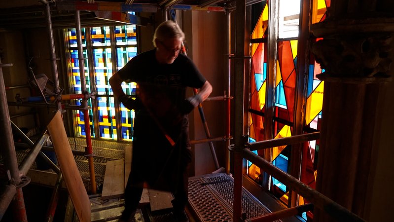 Mann setzt letzte Fenster in einer Kirche ein | Bild: BR Mann setzt letzte Fenster in einer Kirche ein
