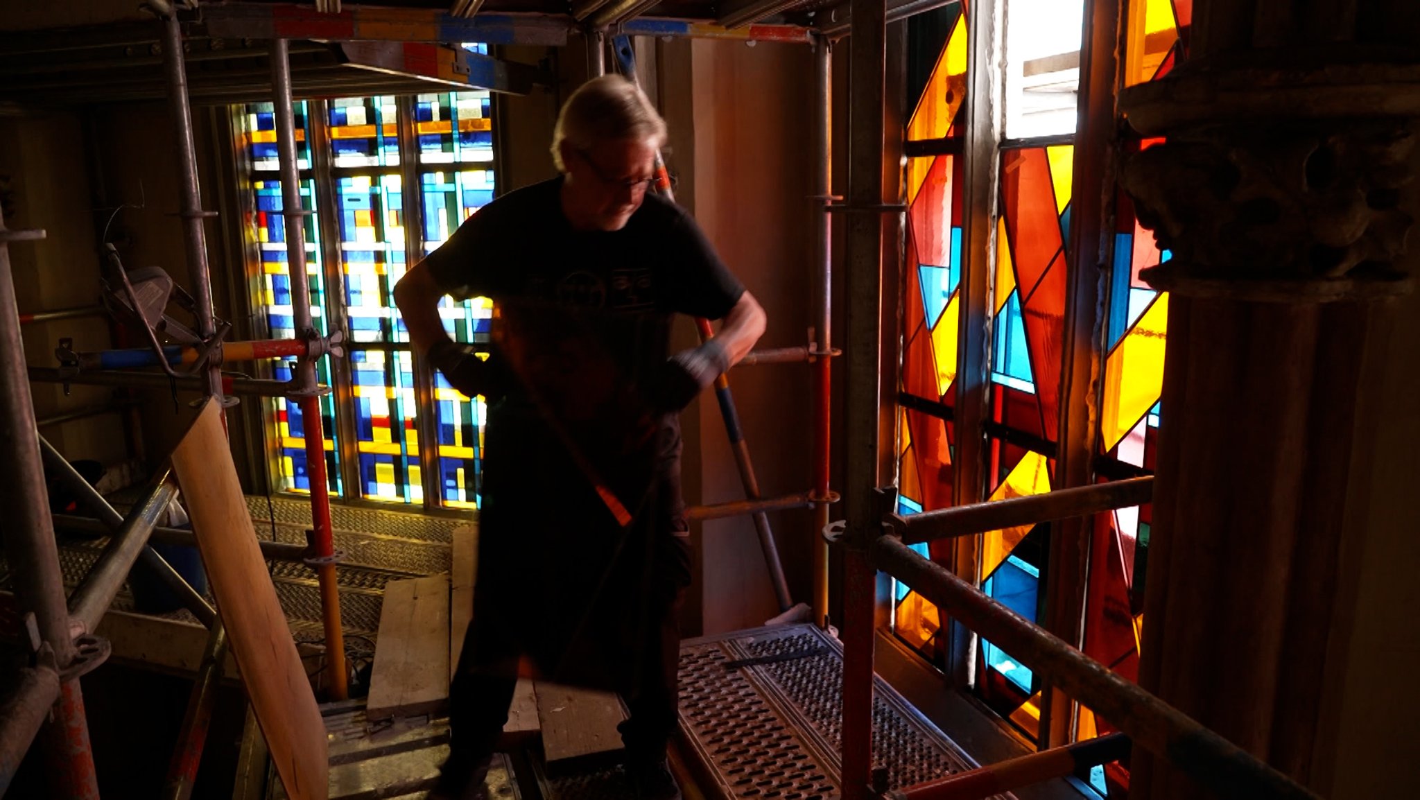 Mann setzt letzte Fenster in einer Kirche ein