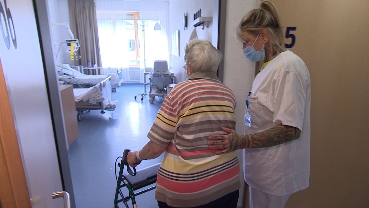 Am Uniklinikum Würzburg hilft eine Pflegerin einer Patientin ins Zimmer