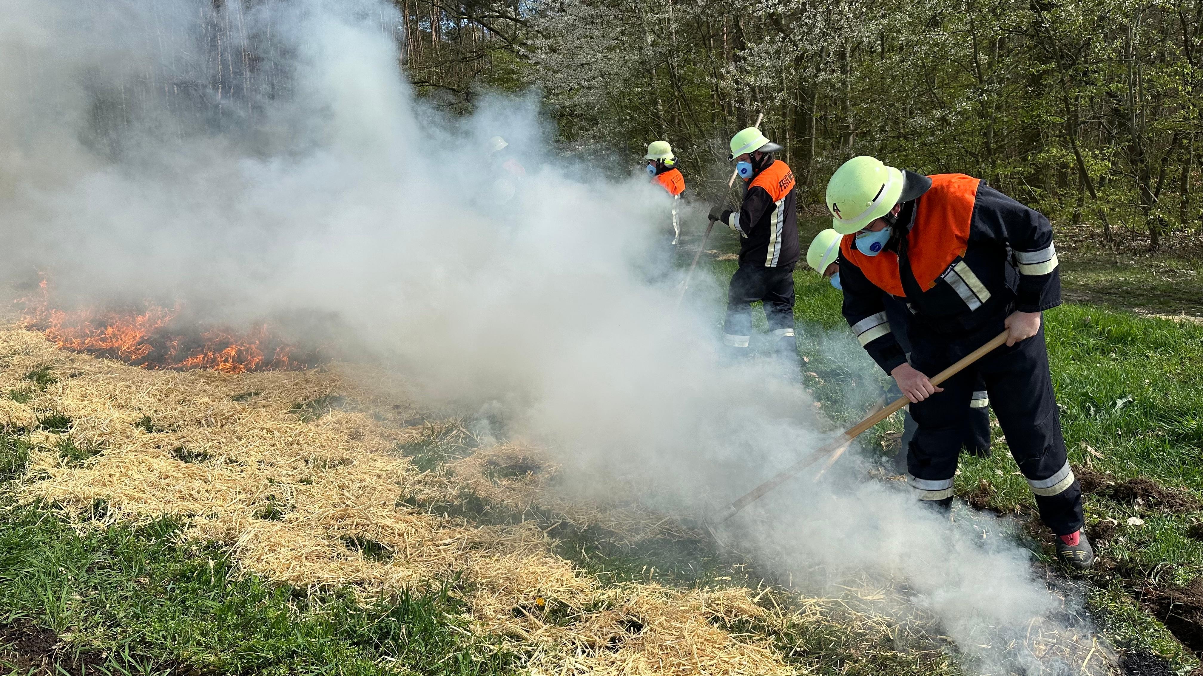 Feuerwehrleute löschen brennendes Stroh