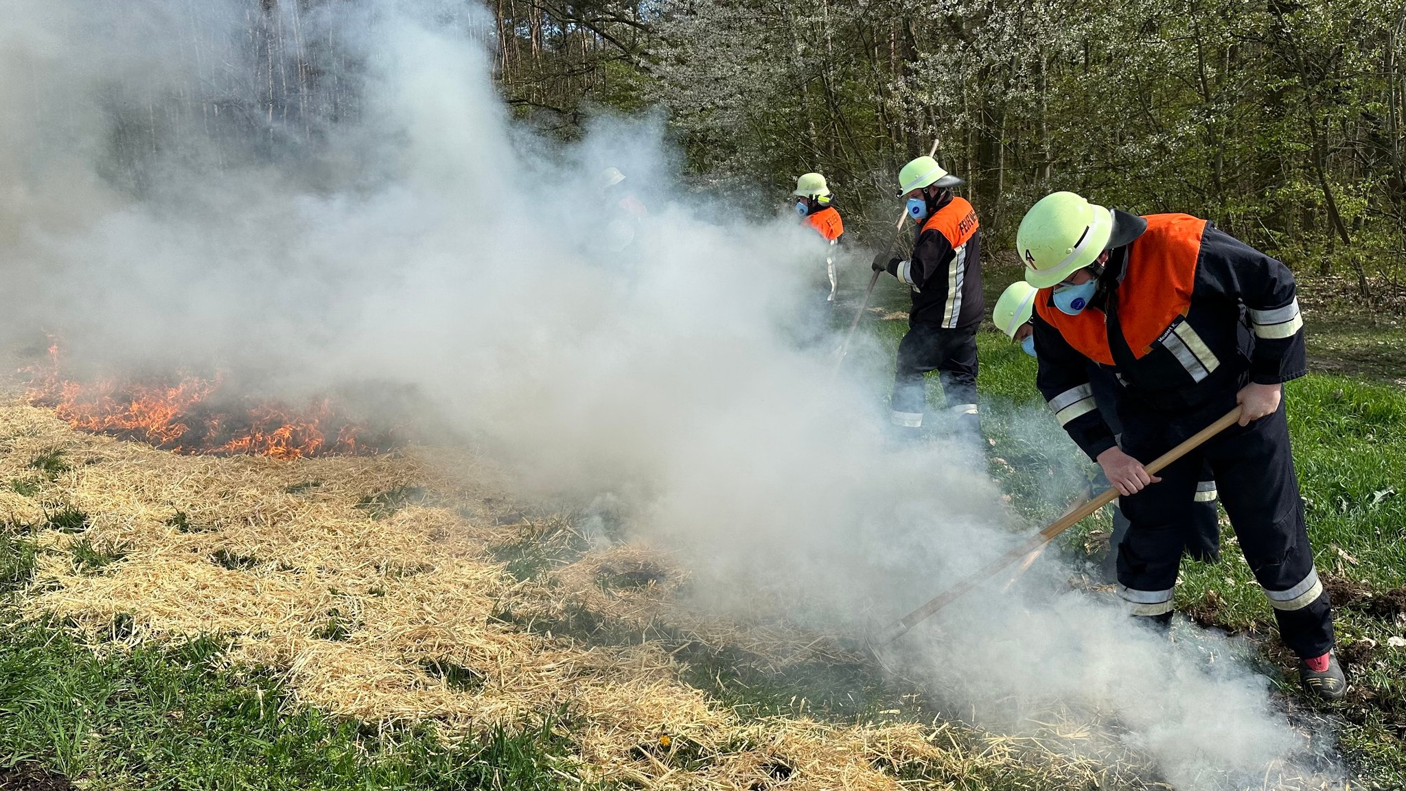 Feuerwehrleute löschen brennendes Stroh