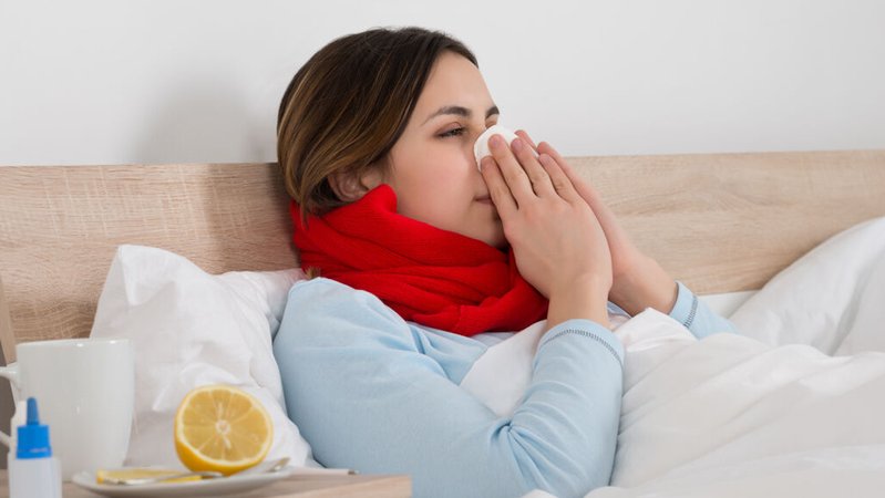 Eine erkältete Frau liegt im Bett und schnäuzt. | Bild: stock.adobe.com/Andrey Popov Eine erkältete Frau liegt im Bett und schnäuzt.