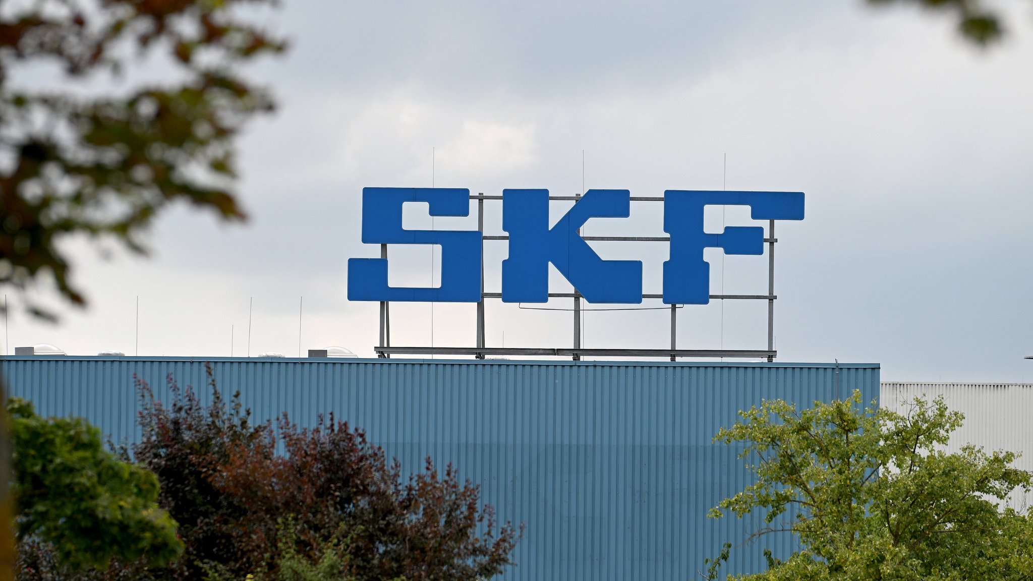 Eine Halle von SKF in Schweinfurt mit den drei Buchstaben "SKF" in blau. | Bild: picture alliance / Jens Niering | Jens Niering Eine Halle von SKF in Schweinfurt mit den drei Buchstaben "SKF" in blau.