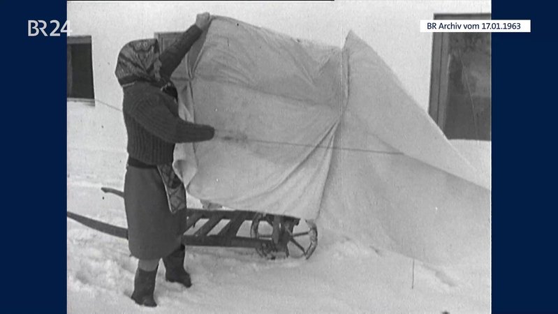 Frau beim Abhängen von gefrorener Wäsche | Bild: BR-Archiv Frau beim Abhängen von gefrorener Wäsche