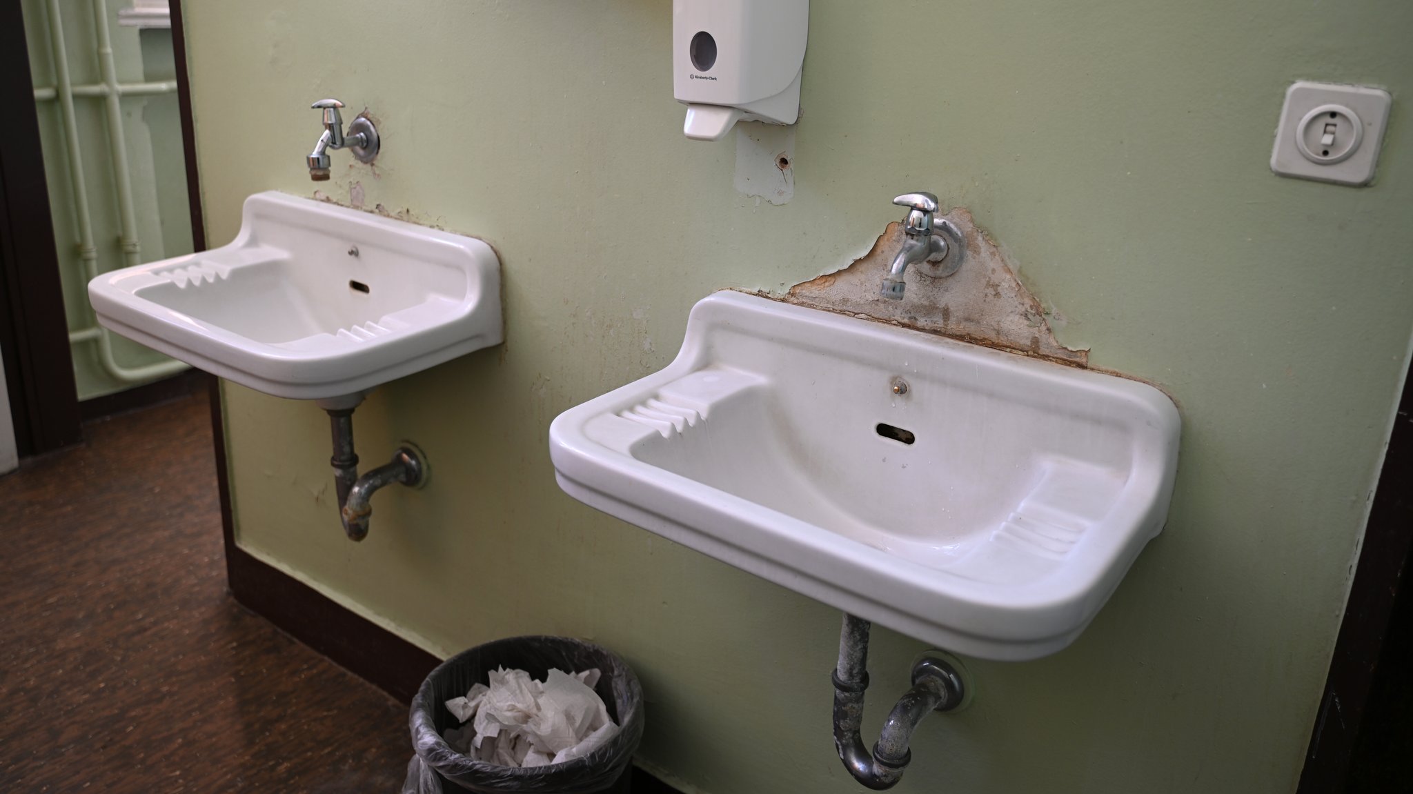(Symbolbild) Zwei Waschbecken mit großen Wasserflecken in der Schultoilette. | Bild: picture alliance/dpa | Elisa Schu (Symbolbild) Zwei Waschbecken mit großen Wasserflecken in der Schultoilette.